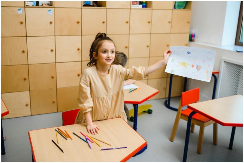 Smiling girl proudly showing her drawing in a vibr