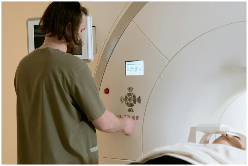 A healthcare worker operates an MRI scanner with a
