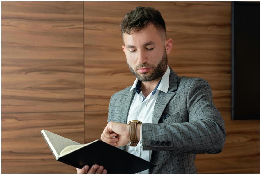 Young businessman in gray suit checking wristwatch