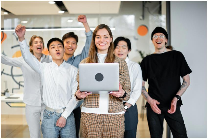 A cheerful, diverse team celebrates success in a m
