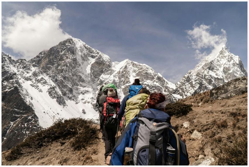 Group of hikers trekking on a sunny day with snow-