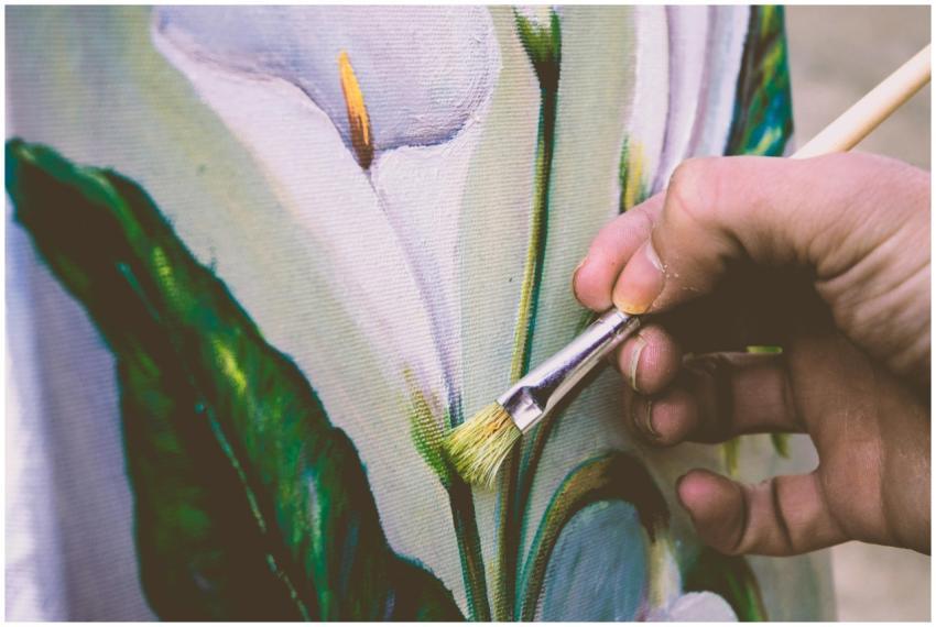 Close-up view of an artist painting a floral desig
