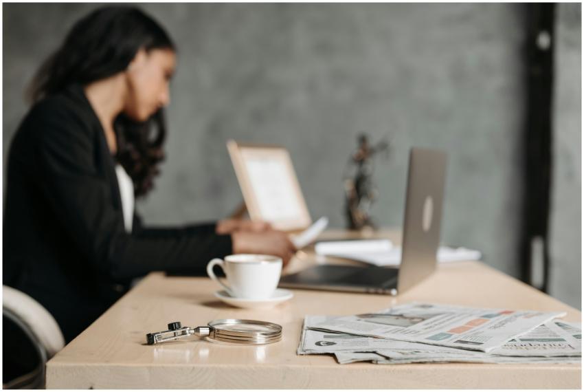 A woman in a business suit working at a desk with