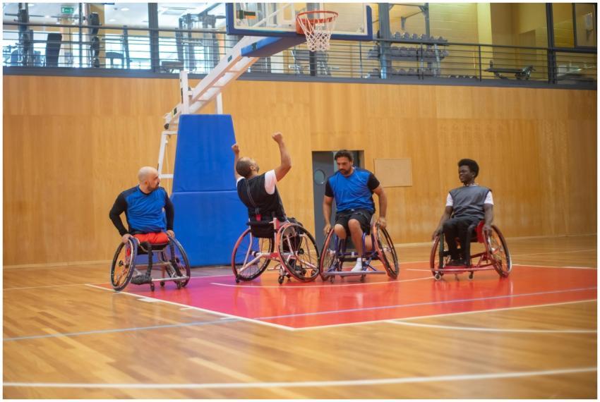 Four male wheelchair basketball players celebratin