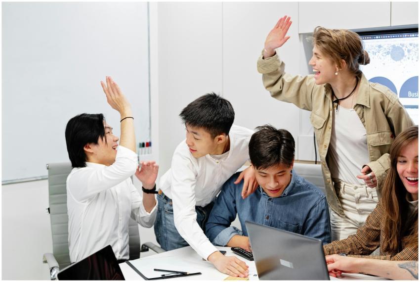 A diverse group of coworkers sharing a joyful high