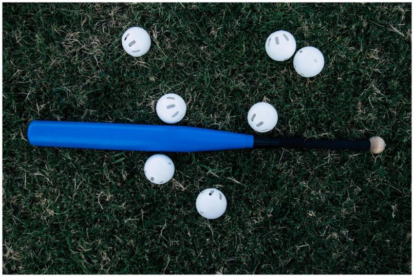 A blue baseball bat surrounded by white practice b