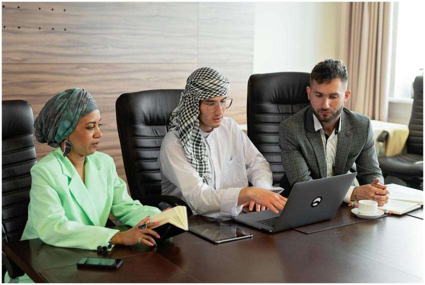 Three business professionals discussing over a lap