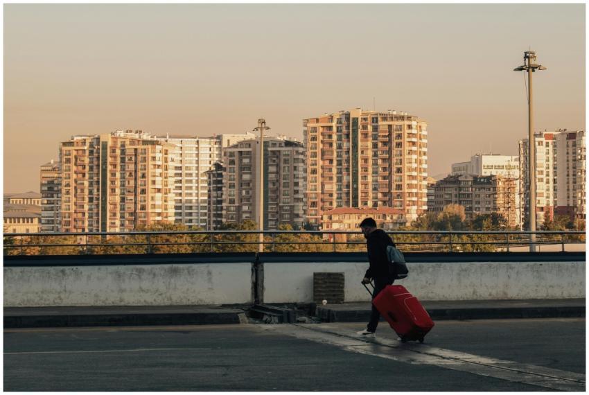 Silhouette of a person with a red suitcase against