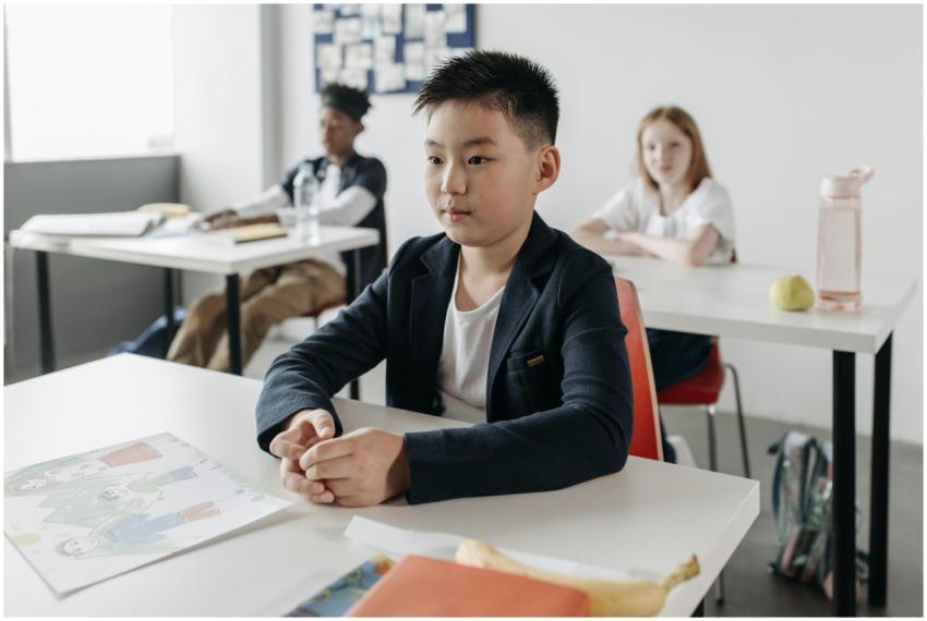 Young student focused in class, sitting at a desk