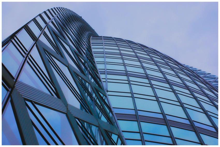 Low angle view of a modern glass skyscraper with b