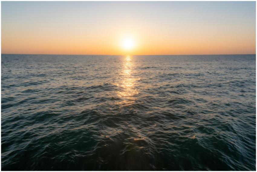 Beautiful sunset over the ocean with golden reflec