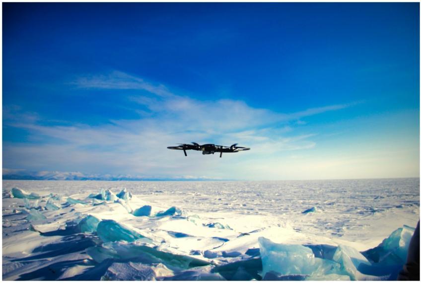 Drone navigating over a vast, icy landscape under