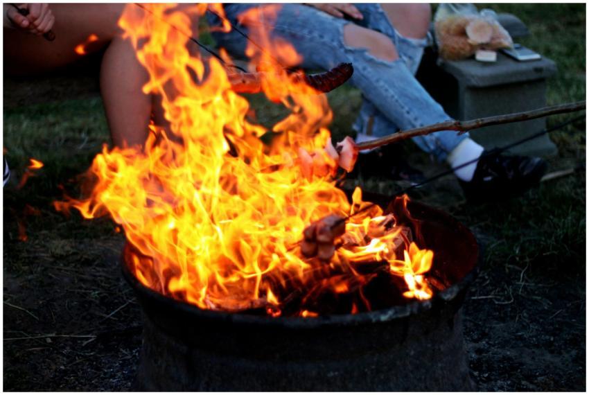 Close-up of a lively campfire cookout with people