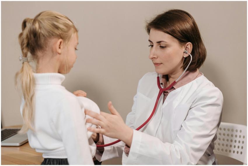 Doctor performing a health check-up on a child usi