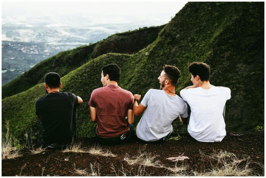 Four friends enjoying a scenic mountain view, symb