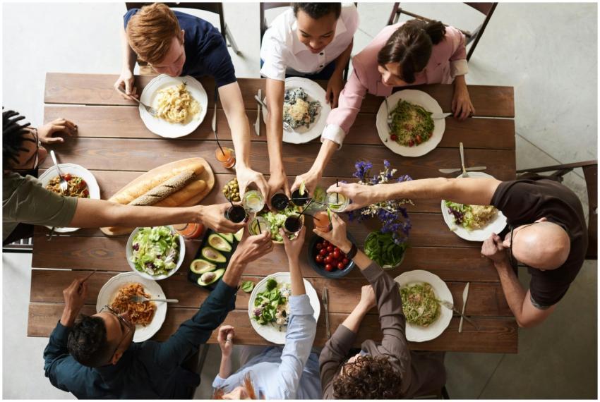 A vibrant group cheers over a delicious meal, show