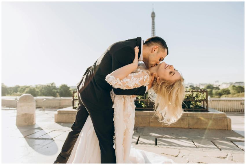 A joyful bride and groom kiss with the Eiffel Towe