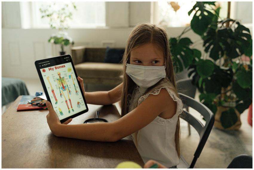 Girl using a tablet to study anatomy, wearing a fa
