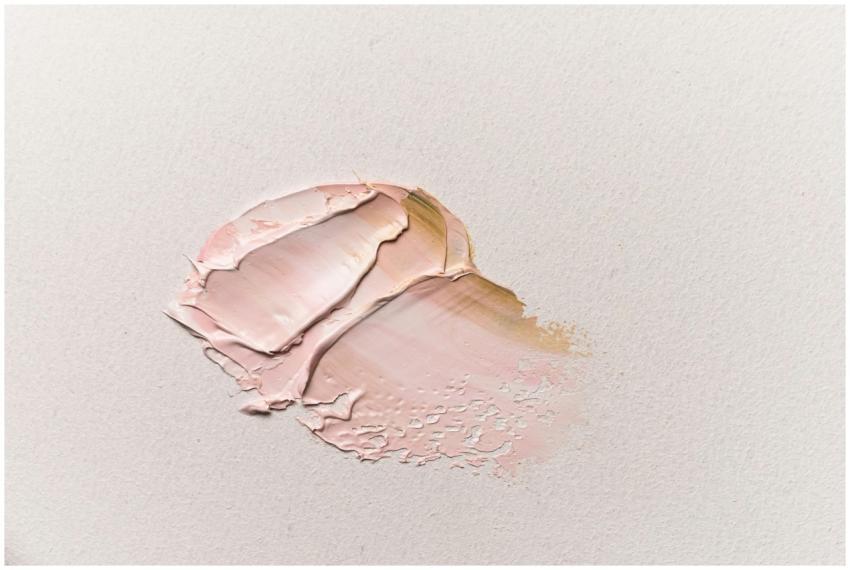 A detailed close-up of pink oil paint smeared on t