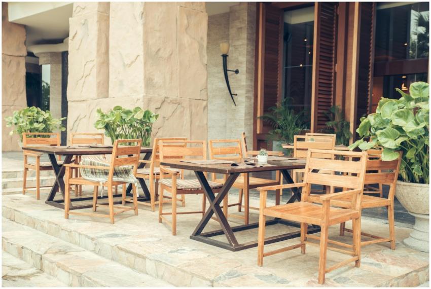 Elegant outdoor café area with wooden chairs and t
