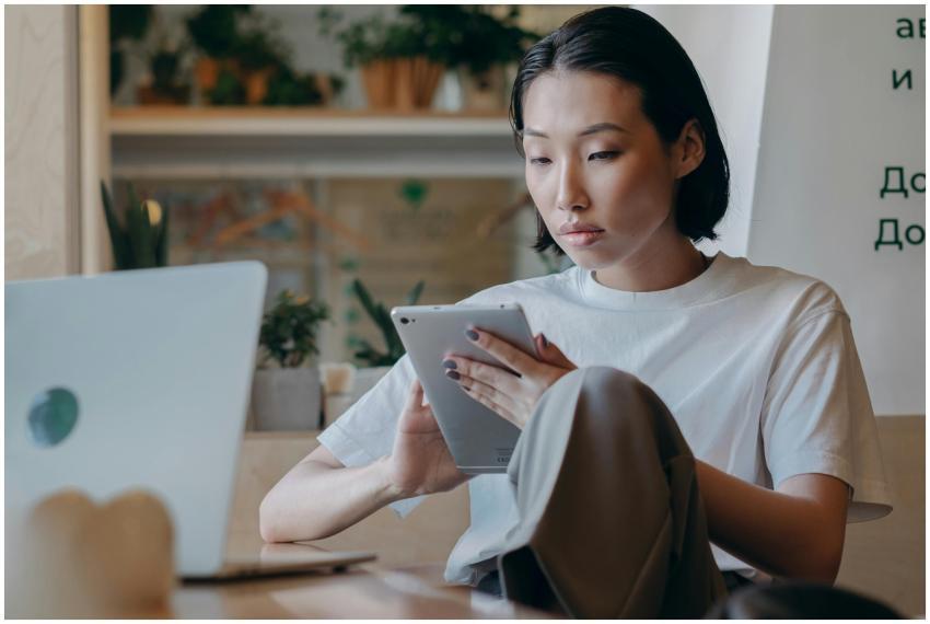 Focused Asian businesswoman using a tablet in a mo