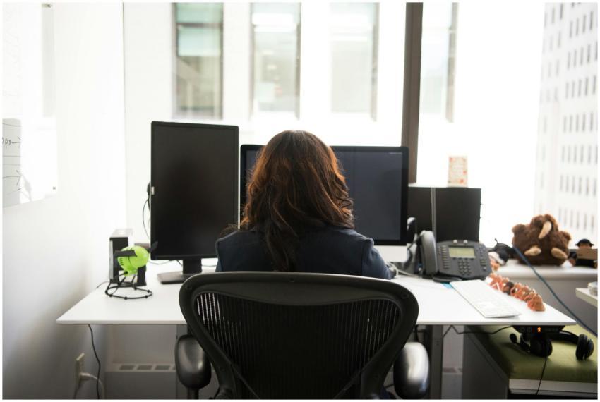 Woman working at a desktop setup in a modern offic