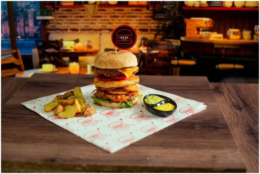 Gourmet cheeseburger with chips and pickles served