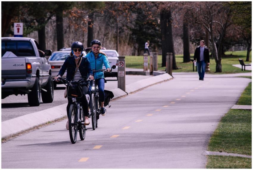 Two women cycling on an urban bike path in a park