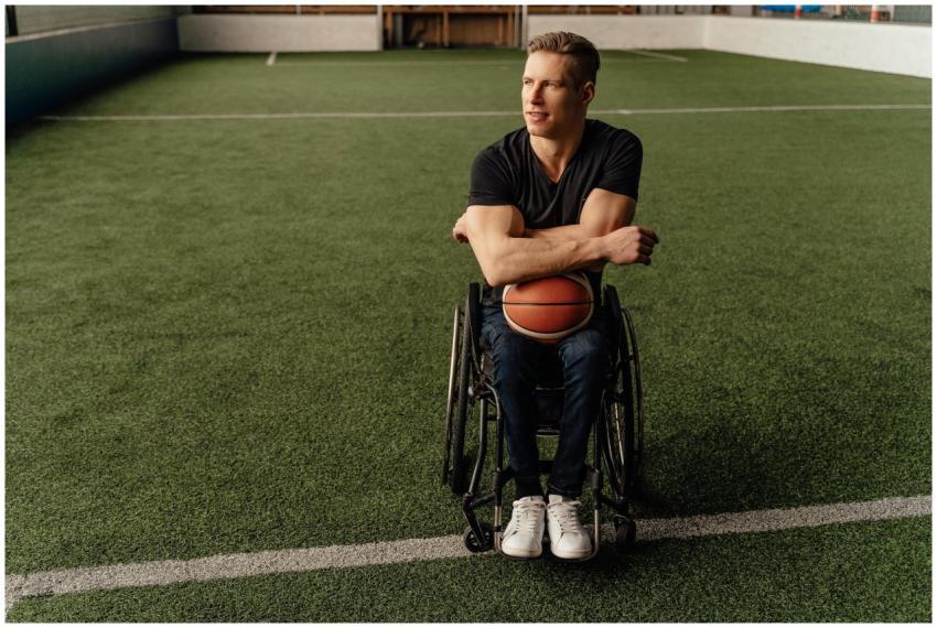 Adult man in wheelchair holding basketball on the