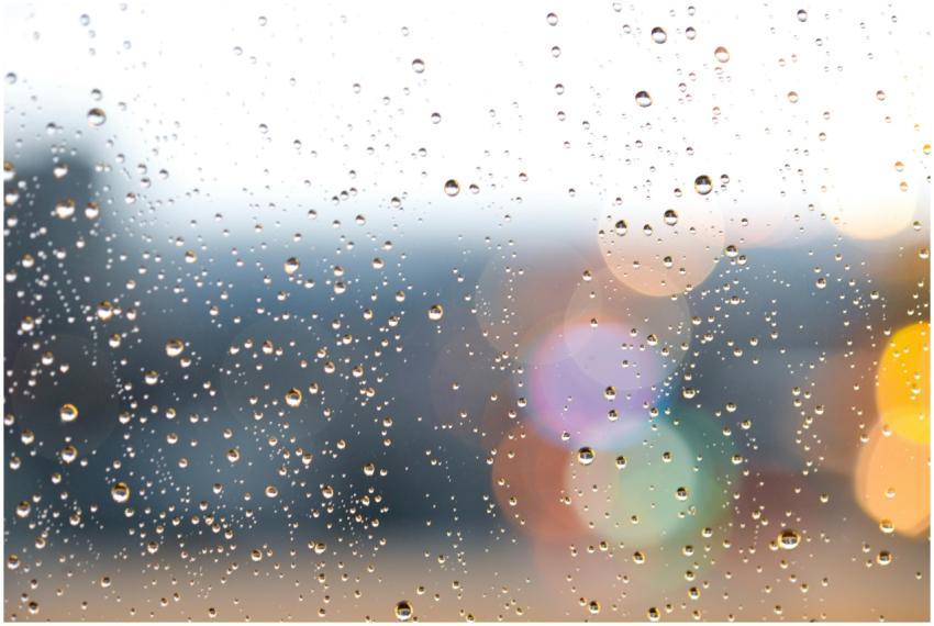 Raindrops on a window with colorful bokeh lights i