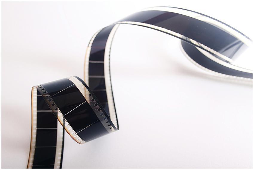 Close-up of a curled filmstrip against a white bac