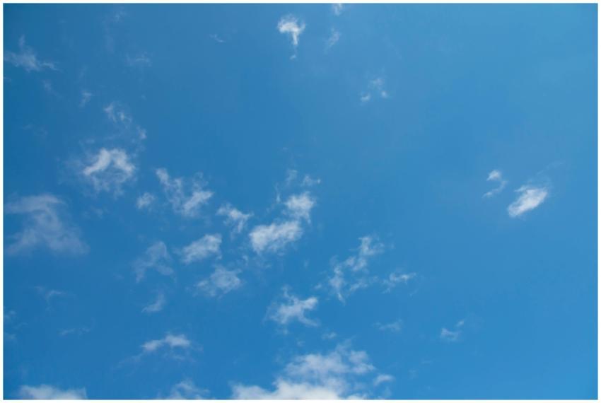 Bright blue sky with scattered fluffy white clouds