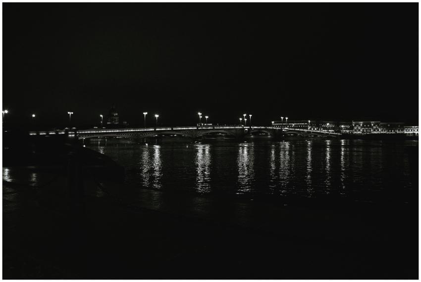 A serene black and white nighttime view of a lit b