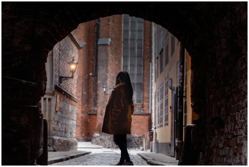 Silhouette of a woman in a long coat standing in a