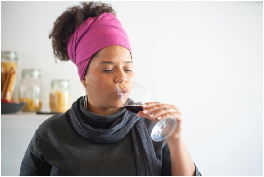 A woman savoring red wine in a cozy indoor setting