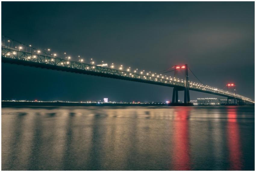 A beautifully lit suspension bridge reflecting on