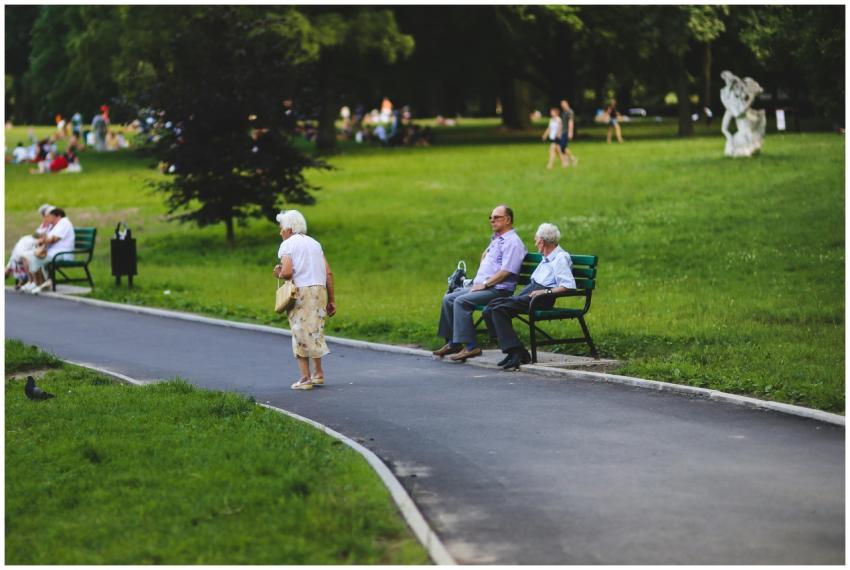 Elderly people sitting on benches enjoying a sunny