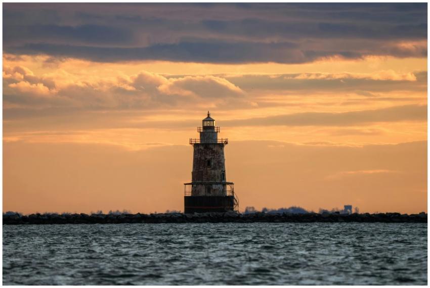 Scenic view of a solitary lighthouse at sunset wit