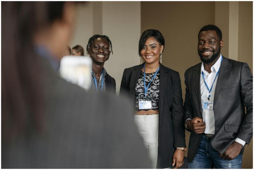 Three business professionals smiling at a corporat