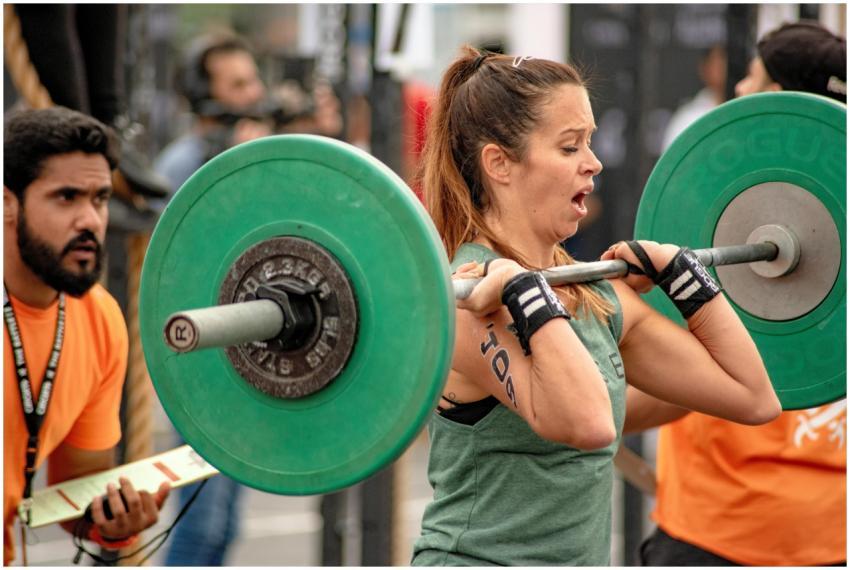 Female athlete performing weightlifting in an outd