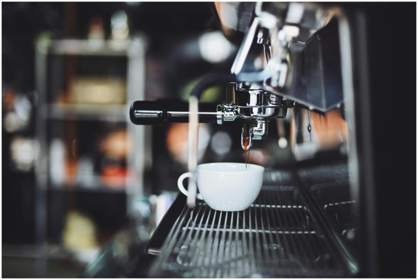 Espresso shot pouring into a cup from a coffee mac
