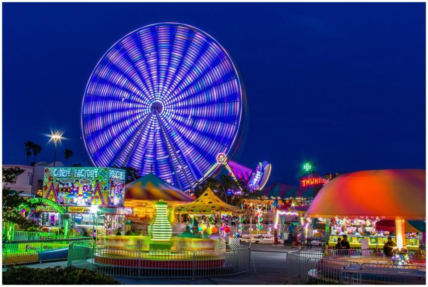Brightly lit amusement park with a spinning Ferris