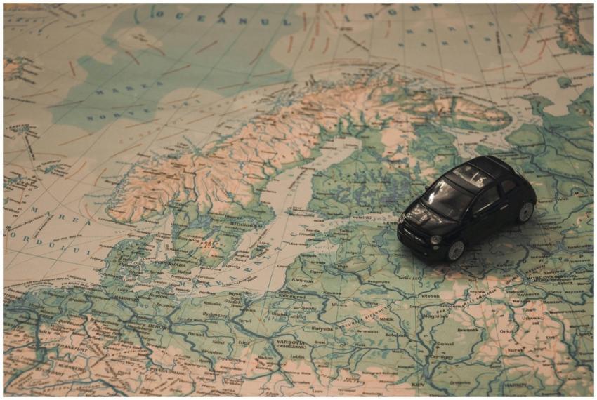 A miniature black car on a detailed map of Scandin