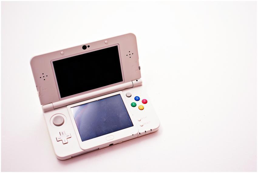 A clean shot of a white portable gaming console wi