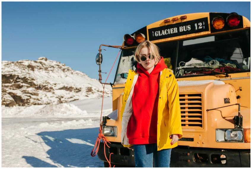 A trendy woman poses in winter attire next to the