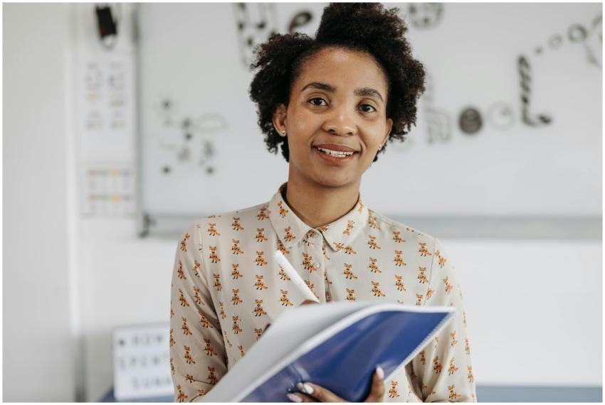 Confident female teacher smiling while holding a n