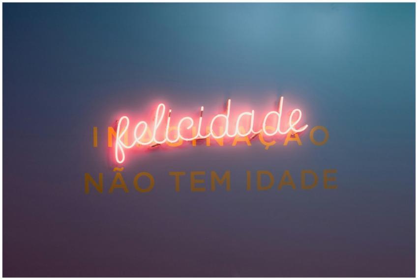Glowing neon sign 'felicidade' on a dark backgroun