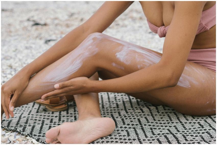 Close-up of a woman applying sunscreen on her legs