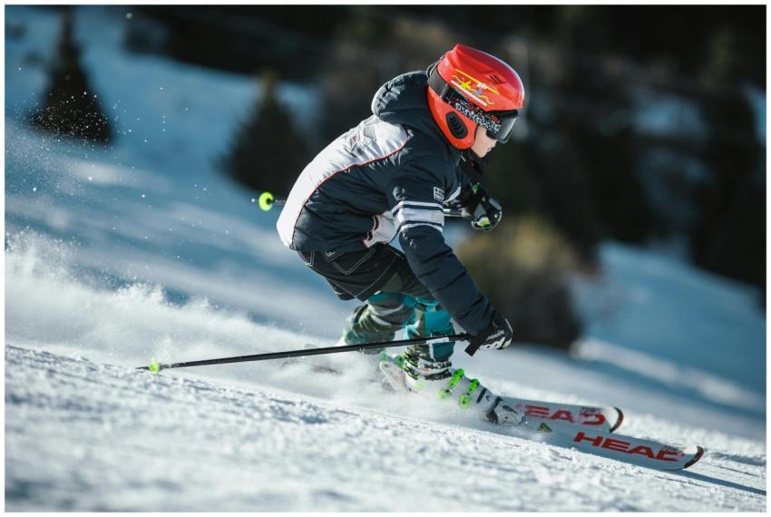 A skier in motion wearing winter gear, gliding swi