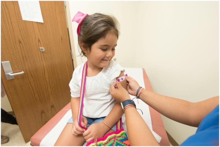 A cheerful young girl receives a band-aid after a
